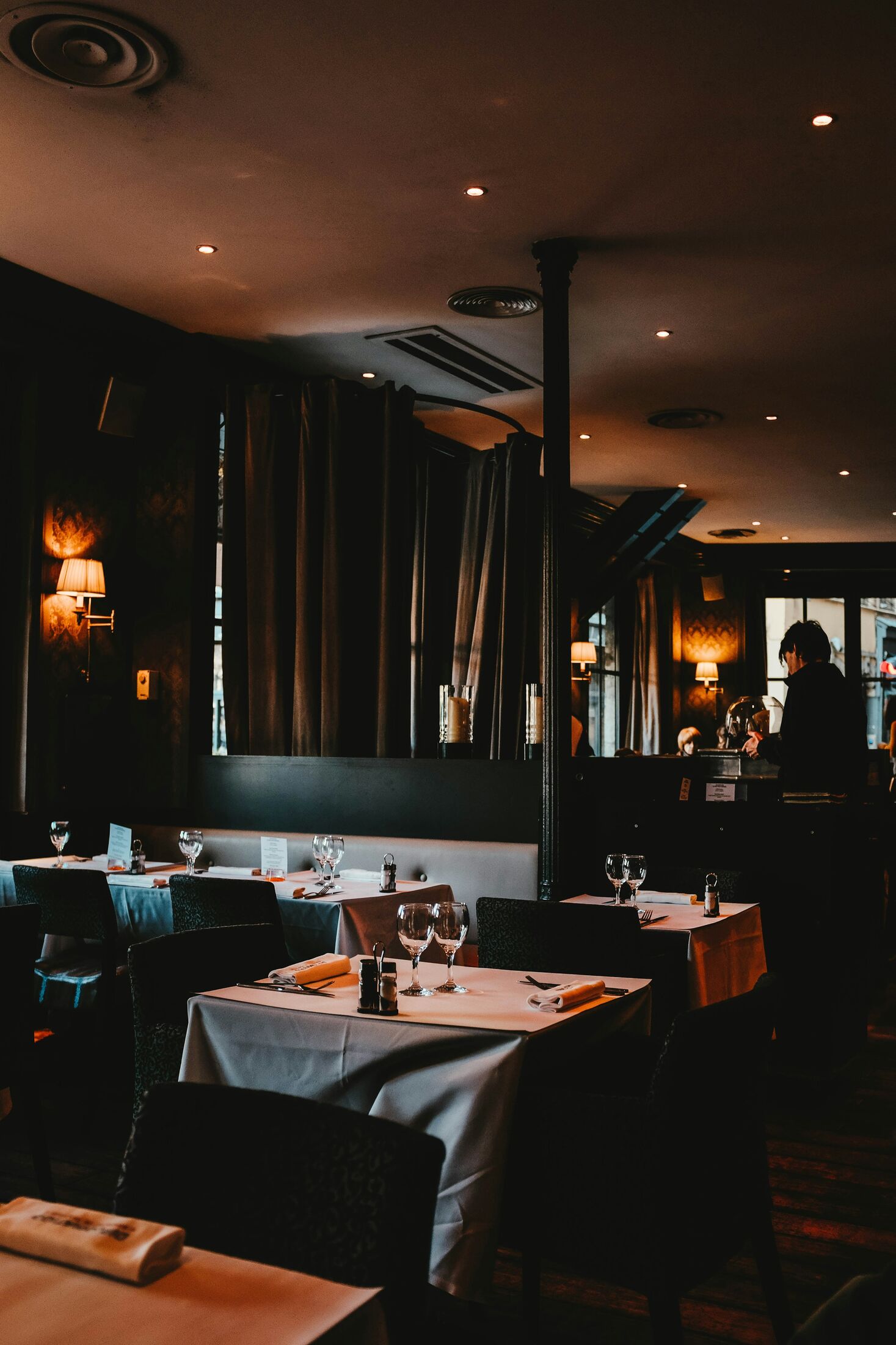 The dining room in the evening, lamps lit and tables set